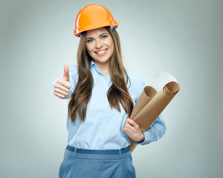 Smiling business woman builder holding rolled up technical drawing