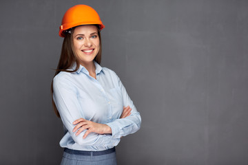 smiling woman architect standing against grey wall.