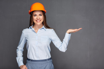 Woman wearing builder helmet presenting empty hands