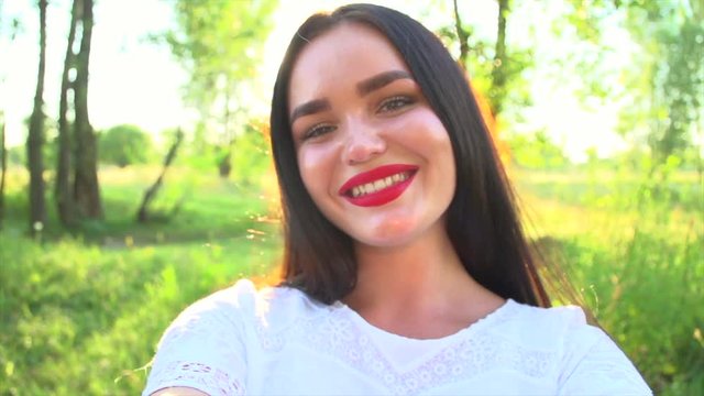 Beautiful young woman taking selfie at sunset. Beauty model girl enjoying nature outdoors. Slow motion 240 fps. 4K UHD video 3840x2160