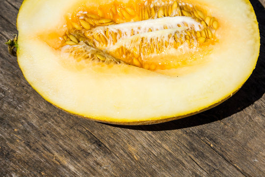 Half of melon on rustic wooden background