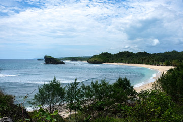 Fototapeta na wymiar perfect vacation - tropical bay with white sand and perfect waves for surfing close to Pacitan beach