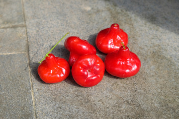 fruits on the floor - five fresh red rose apples on the gray floor