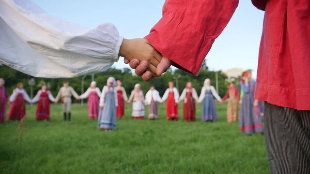 Russian folk circle group dance - men and woman in national folk costume outdoor