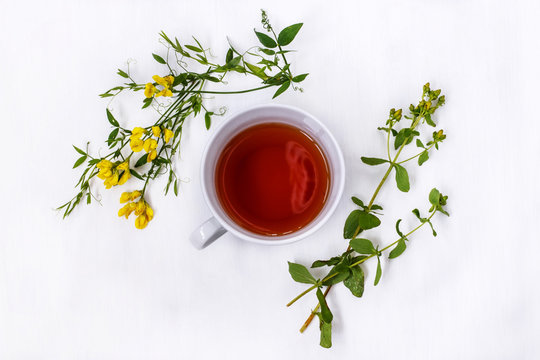 Cup Of Black Tea With Wild Medicinal Flowers On A White Background