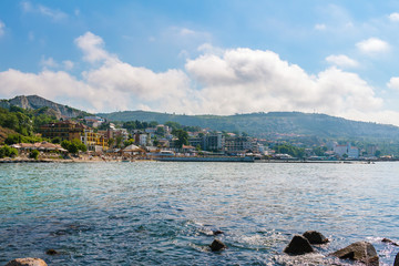 Fototapeta premium View from the sea to the city balchik, cityscape, houses and apartment buildings on the shore and hills in black sea coast, Bulgaria