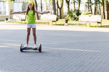 Happy girl  riding on hover board  or gyroscooter  outdoors at sunset in summer. Active life concept