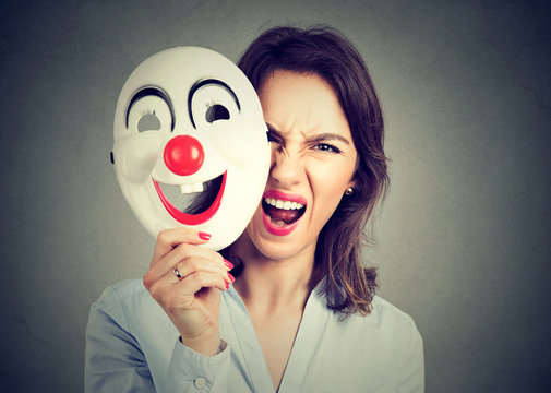 angry screaming woman taking off happy clown mask
