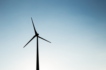 Obraz premium Wind turbine silhouette during sunset