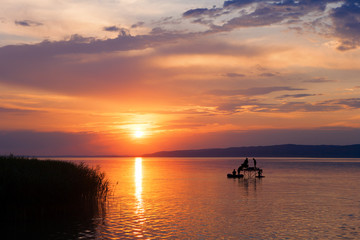 Sunset over Lake Balaton with anglers' silhouettes in Hungary