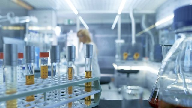 Point of View Shot of a Moving Cart with Test-Tubes, Analysis, Beakers and Various Glassware. Scientist Takes Some of Test-Tubes for Herself. Shot on RED EPIC-W 8K Helium Cinema Camera.