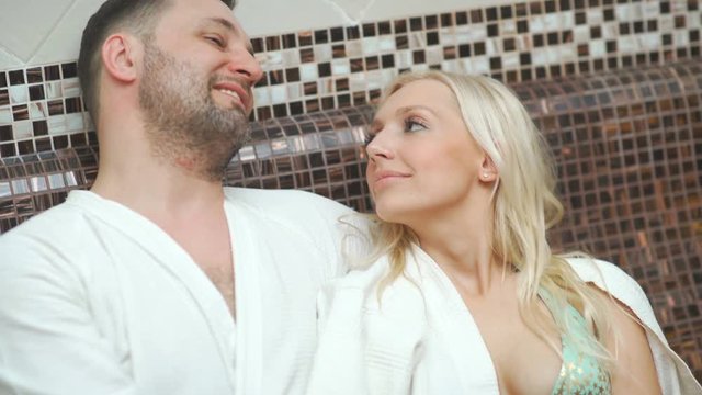 A family of four in hamam, a Turkish steam room. Young parents with two sons in the thermal zone bask in the hamam. A healthy young family with two children in a ham. Thermal center, hammam, spa