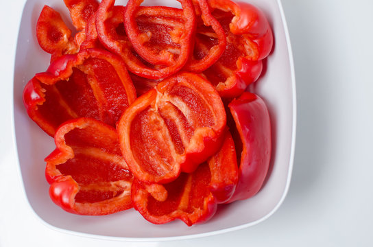 red bell peppers in a white bowl on a white background