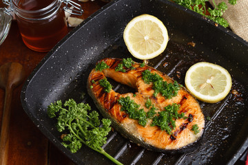 Pan grilled salmon steak on wooden table and high angle view