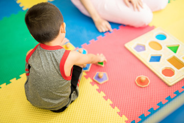 Little boy learning different shapes during children therapy