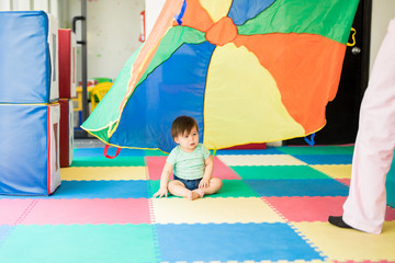 Baby looking at a colorful parachute