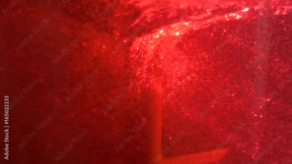 Poster close-up of colorful flask in which the liquid is mixed by a special device