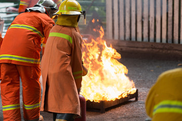 Instructor showing how to use a fire extinguisher. Gas tanks with fire. during training