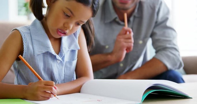 Father helping daughter with her school project