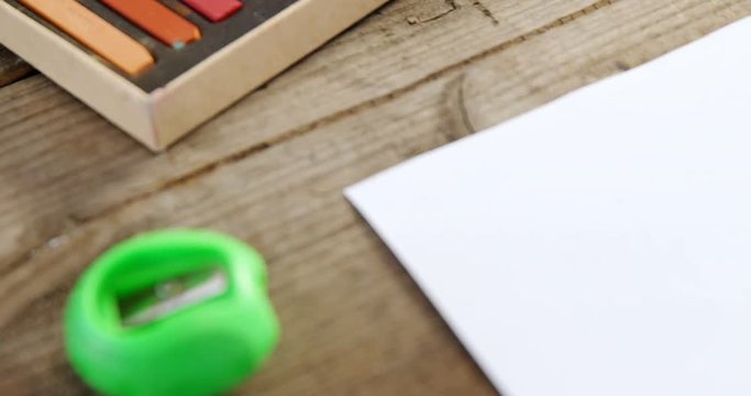 Watercolor paint box and sharpener on wooden table
