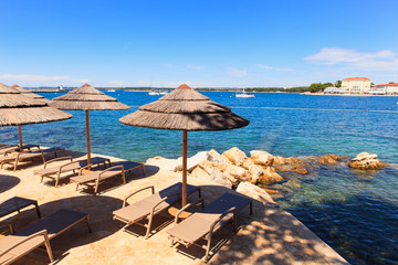 Beach umbrellas in Saint Nicholas island in Porec, Istria. Croatia