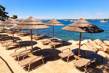 Beach umbrellas in Saint Nicholas island in Porec, Istria. Croatia