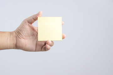 Hand holding sticky post note paper sheet