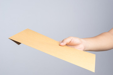 Hand holding a self sealing brown envelope document
