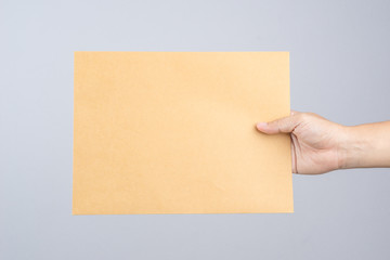 Hand holding a self sealing brown envelope document