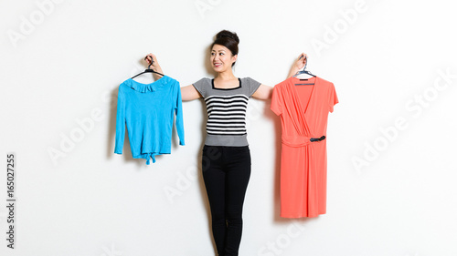 2種類の服で迷っている女性 ファッションイメージ Wall Mural Beeboys