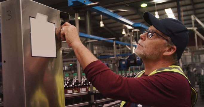 Worker checking machine next to production line
