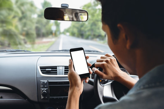 man looking at phone inside car