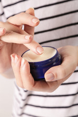 Closeup of female hands applying cream