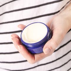 Closeup of female hands applying cream