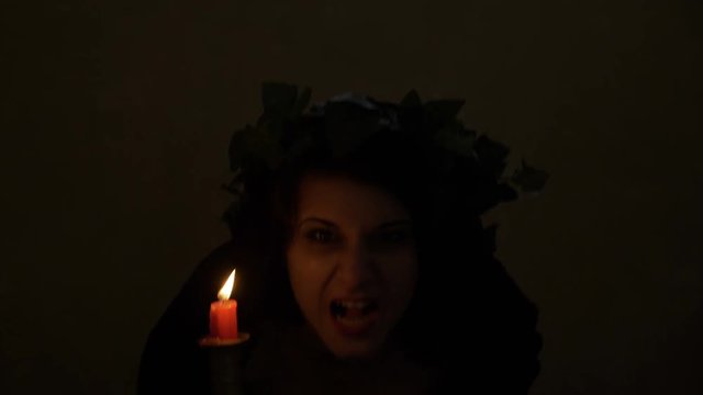 Scary vampire woman with black veil snarling in the darkness ready for attack