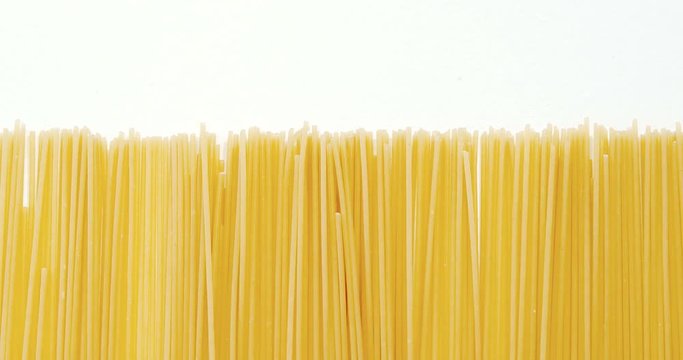 Raw spaghetti arranged on white background