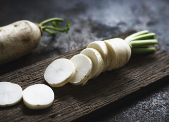Closeup of cut daikon radish on wooden cutboard © Rawpixel.com