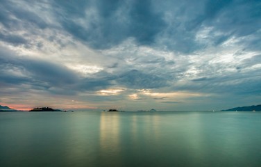 Nha Trang Vietnam sunrise with a cloudy grey sky over a turquoise ocean long exposure.