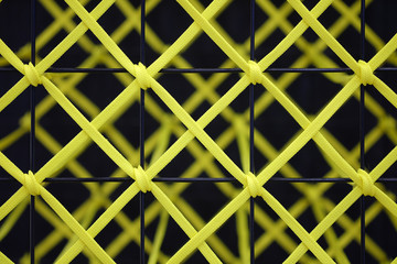 Yellow rope tied to a black steel grill, Abstract texture background