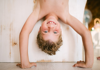 Boy blond standing upside down on his hands