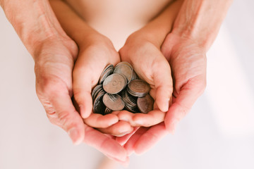 Coins in the hands of mother and child.