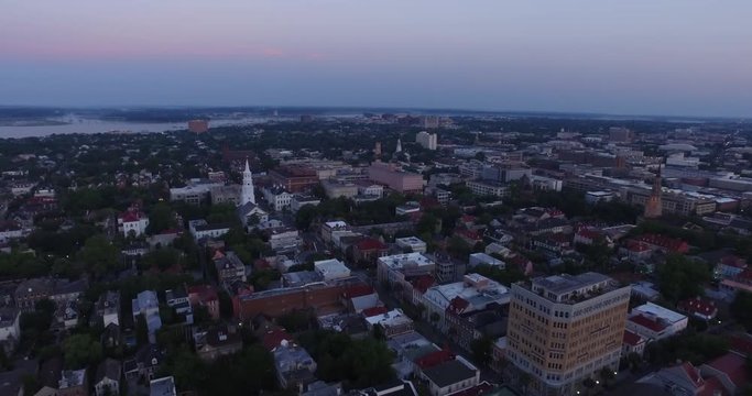 Aerial of Charleston, SC rooftops and church steeples at dawn with the Ashley river in view.