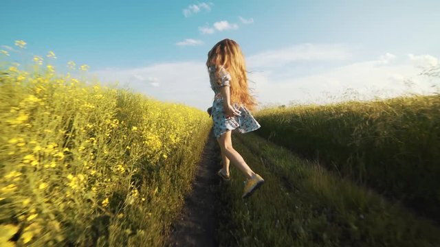 A girl with long hair running down the road on a sunny summer day, vacation.