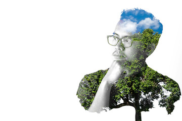 Asian men wearing eyeglasses are thinking of something, Double exposure, trees and blue sky. Space...
