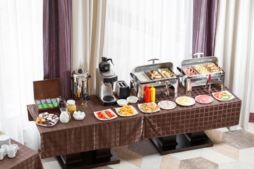 Fototapeta na wymiar Breakfast at the hotel. Buffet Table with dishware waiting for guests
