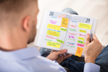 Man Writing Important Notes In Diary