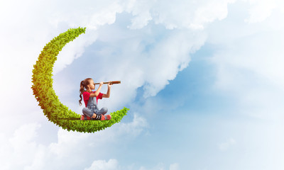 Concept of careless happy childhood with girl on green moon