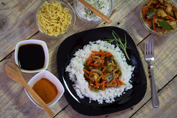Chinese food on the plate with spices served on a wooden table