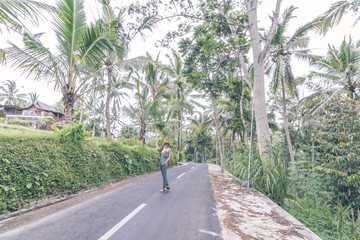 Fototapeta na wymiar Young woman traveler on the road of jungle, tropical Bali island, Indonesia.