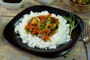 Chinese food on the plate with spices served on a wooden table. Close-up